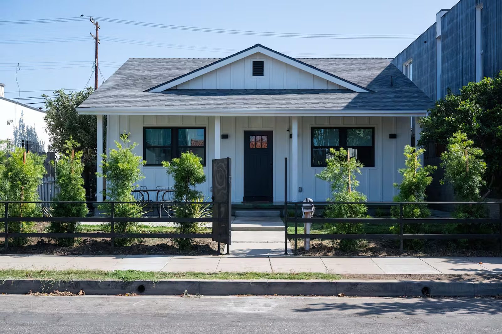 The white board-and-batten front house at 736 Brooks Avenue, Venice, seen from the sidewalk.